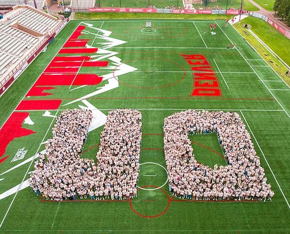 First-year students form a D and U at Peter Barton Lacrosse Stadium for their class of 2028 photo.